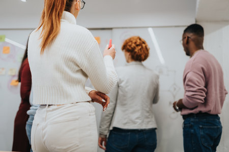 Business colleagues brainstorming and discussing market analysis in a corporate officeの写真素材