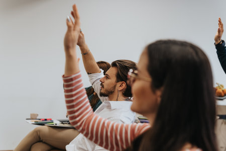Engaged employees raise hands, eager to pose questions during the seminar in the boardroom.の写真素材