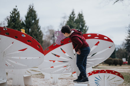 Young boy playing on a butterfly-shaped installation in a parkの写真素材
