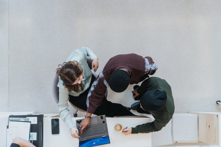 Casual business meeting with young professionals engaging over laptop.の写真素材