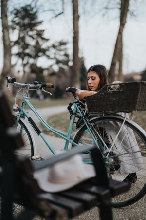 Professional woman enjoying a peaceful moment with bicycle in urban park