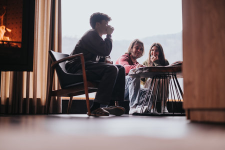 Group of friends enjoying a cozy gathering at home by the fireplaceの写真素材