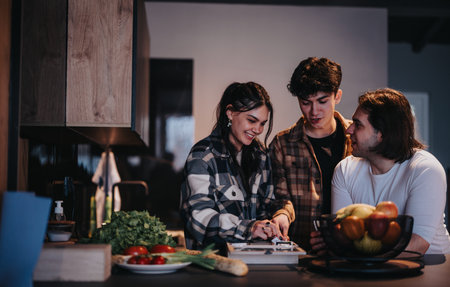 Casual friends gathering at home, enjoying time together in the kitchenの写真素材