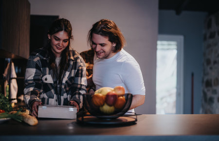 Friends sharing a casual moment cooking together at homeの写真素材
