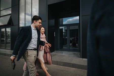 Confident businessman walking with partner outside a modern office buildingの写真素材