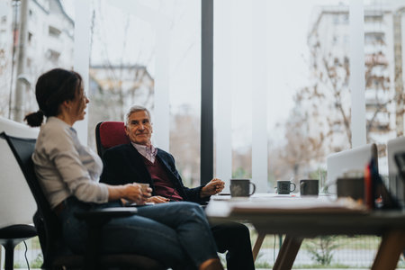 Senior businessman and female colleague having a discussion in officeの写真素材