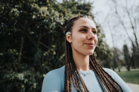 Active young woman with braids enjoying nature in sportswearの写真素材