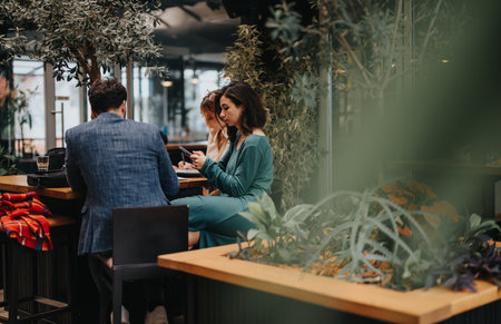 Startup team collaboratively working at an urban coffee shop discussionの写真素材
