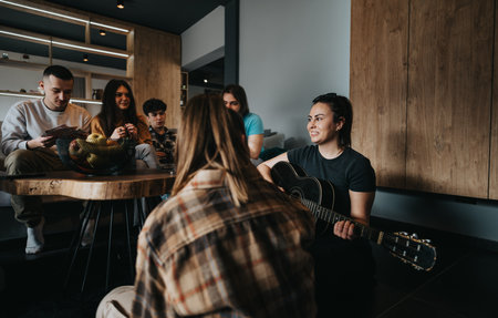 Group of friends enjoying a casual music session with a guitar in a cozy room