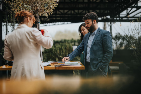 Business partners discussing work together at outdoor cafeの写真素材