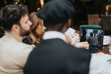 Multiethnic business group collaborating at a cozy cafe. A laptop, papers, and energetic discussion capture the essence of teamwork and strategy.の写真素材