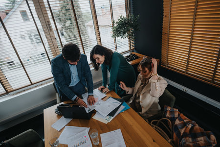 Business associates collaborating in a modern office, analyzing documents and statistics
