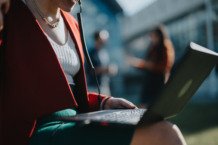 Professional businesswoman working outdoors with laptop on sunny dayの写真素材