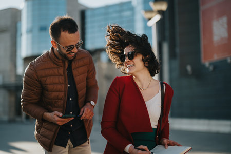 Young business professionals with tablet in urban setting discussing growth strategiesの写真素材