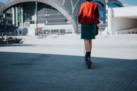 Businesswoman riding electric scooter in city for eco-friendly commuteの写真素材