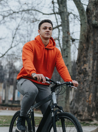 Active young man enjoying a bike ride in a park on a cloudy dayの写真素材