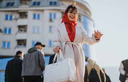 Vibrant young businesswoman with a radiant smile engaging in a strategy discussion with colleagues in an urban outdoor setting.の写真素材