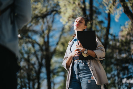 School friends discussion in a sunny park after exams, sharing thoughts and laughsの写真素材