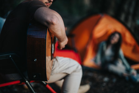 Friends enjoying a relaxing weekend camping by the lake with musicの写真素材