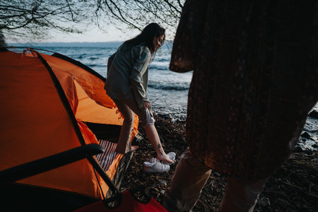 Friends enjoying a peaceful weekend camping by the lakeの写真素材