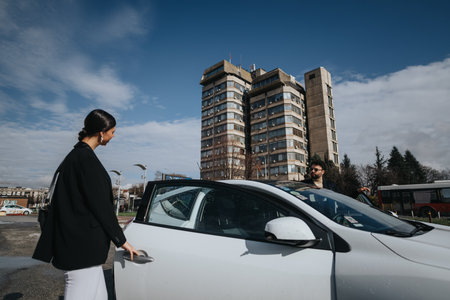 Urban woman in business attire about to drive a modern car in the cityの写真素材