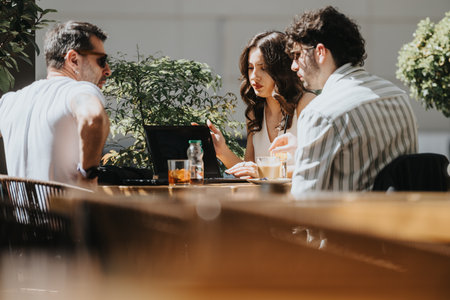 Multigenerational business team brainstorming at a coffee shop, discussing reports for strategic...