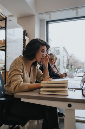 Woman working in an office, discussing business strategies and finding innovative solutions. She...