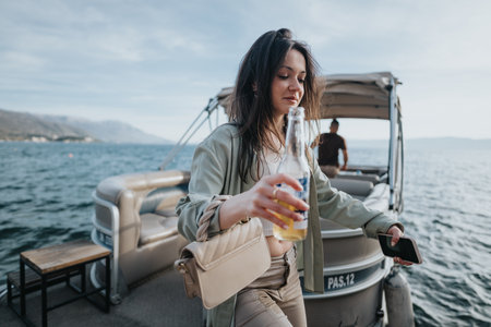 Happy young girl enjoying a boat trip with a fresh drink in handの写真素材