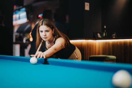 Lovely girl having fun on a night out playing pool at a bar.の写真素材