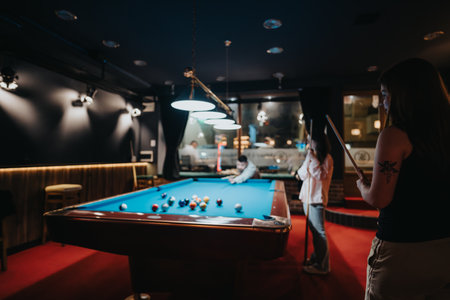 Friends enjoying a game of pool in a dimly lit billiards room, embodying fun and togetherness