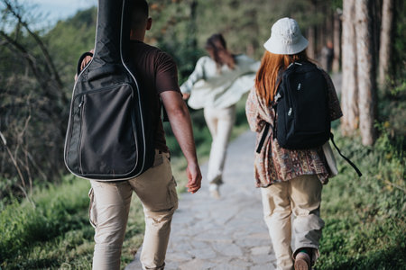 Friends on a forest trail: A carefree adventure in nature with backpacksの写真素材
