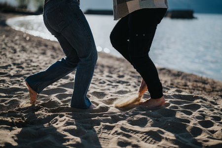 Joyful couple dancing on the beach during a sunny vacation dayの写真素材