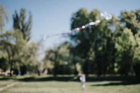 Joyful day in the park: Friends happily flying a kite outdoors in sunlightの写真素材