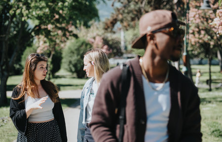 Friends chatting and enjoying a carefree sunny day together in the park