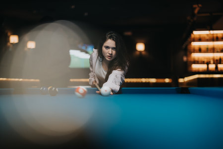Focused woman playing pool in a bar with stylish interior