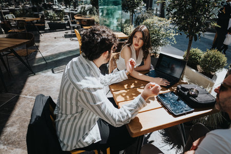Entrepreneurs at coffee bar discussing reports for business growthの写真素材