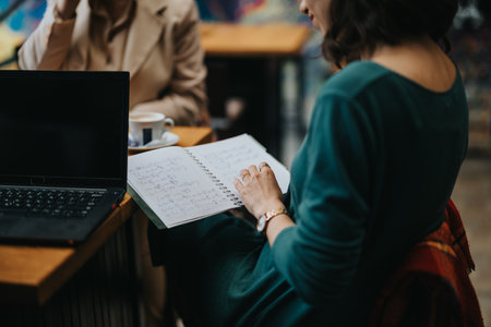 Business partners in a meeting at a cozy cafe with laptop and notesの写真素材