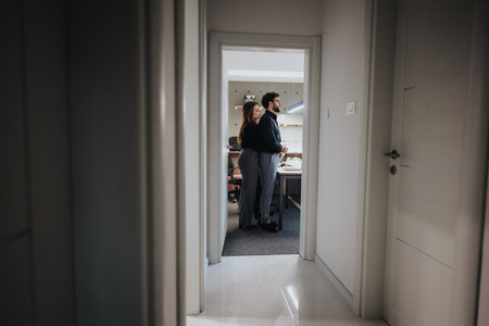 Colleagues in warm hug at the office, capturing a moment of flirting and love at work.の写真素材