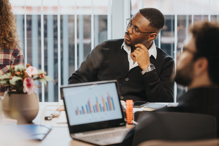 Young business professionals analyzing data in a multicultural office settingの写真素材