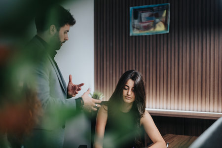 Focused employee receives guidance from manager during a project meetingの写真素材