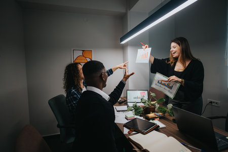 Multicultural team in modern office discussing growth and sales statisticsの写真素材