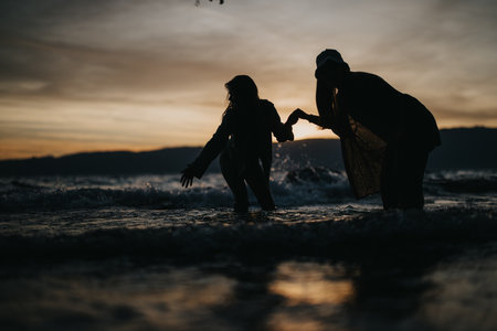 Joyful friends having fun at the lake during a stunning spring sunsetの写真素材