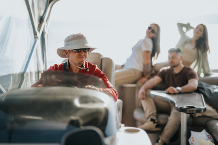 Friends enjoying a boat trip on a sunny lake weekend, showing relaxation and enjoymentの写真素材
