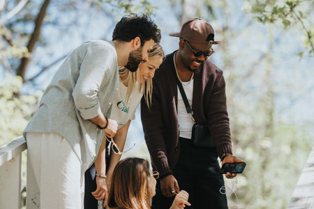 Diverse group of friends sharing a joyous moment in a sunny parkの写真素材