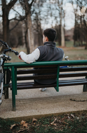 Teen boy with bicycle enjoying a peaceful moment in the parkの写真素材