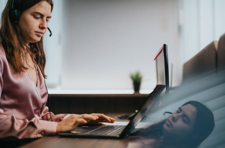 Professional young woman working remotely on a laptop from a modern office