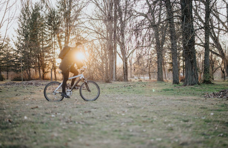 Man riding a bicycle in a park at sunset, nature and fitness conceptの写真素材