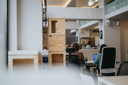 Modern open-plan office environment capturing focused employees at their workstations with stylish minimalist furniture.の写真素材