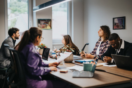 Multiracial team engaged in a business brainstorming session in a modern officeの写真素材