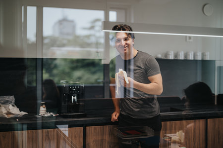 Casual business break: young male worker eating a banana in a modern office kitchen